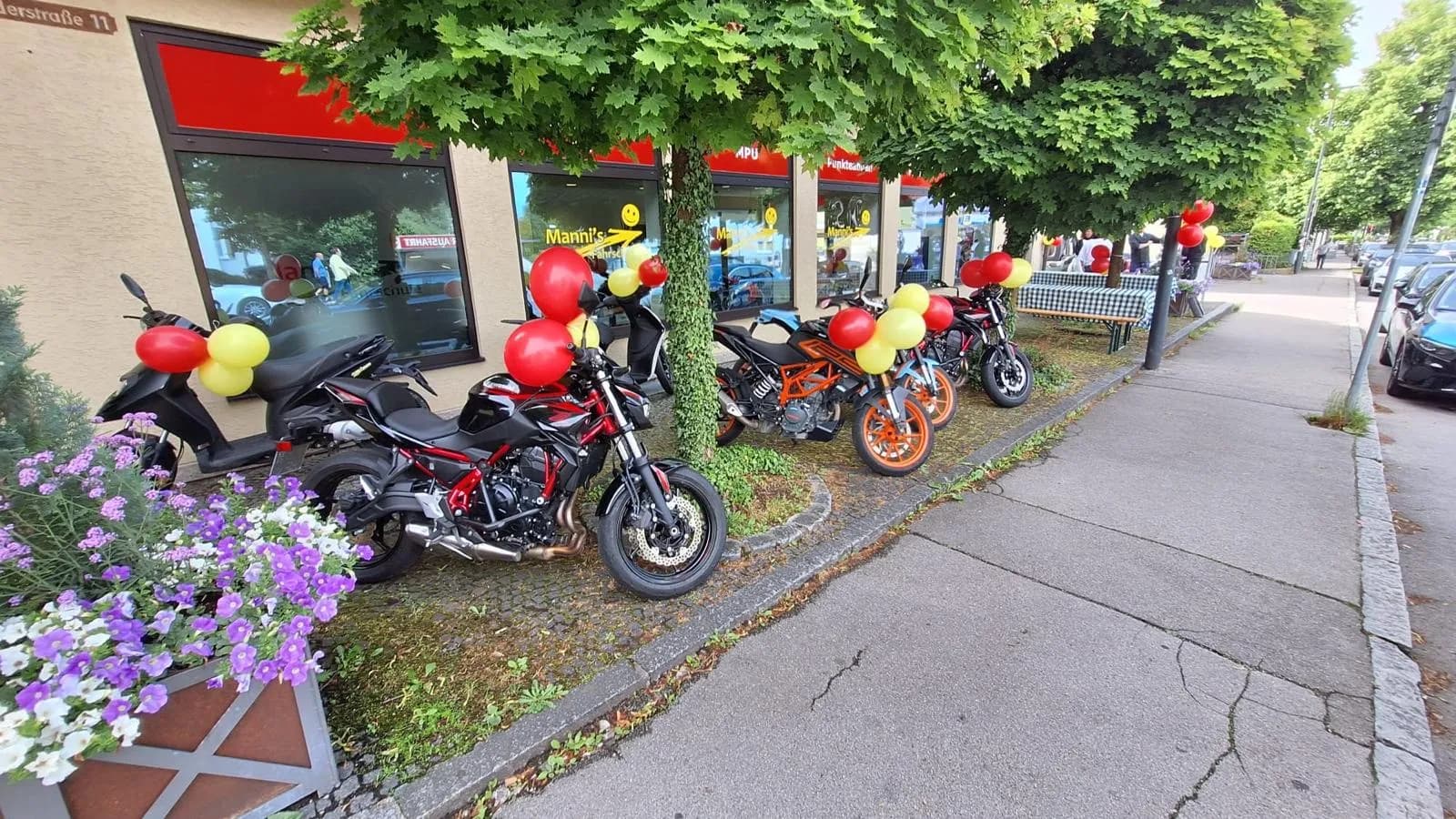 Schulungsmotorräder mit Ballons vor der Fahrschule
